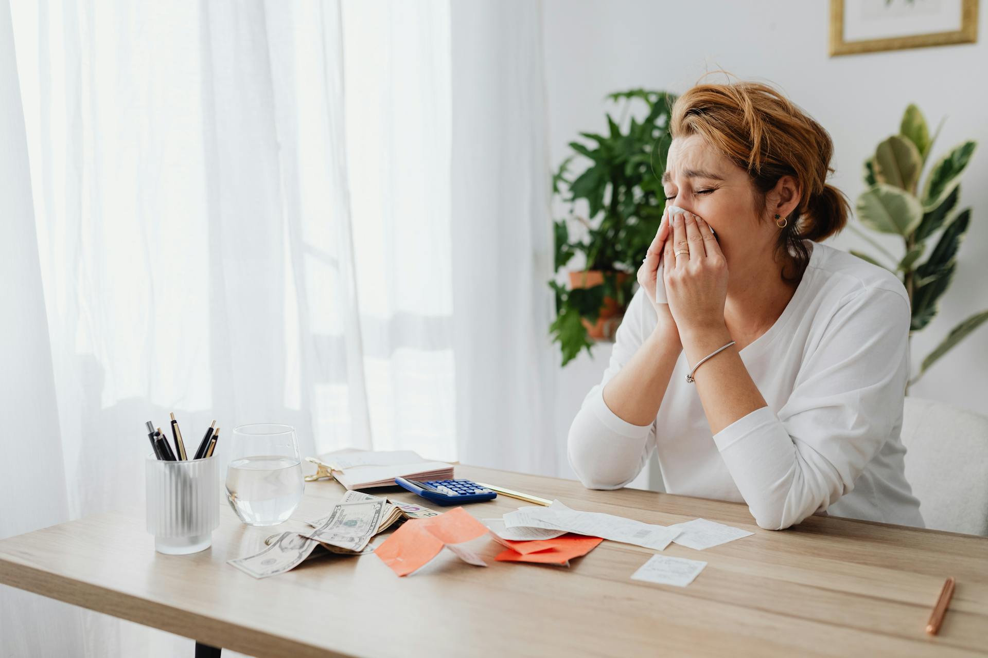 Woman Crying and Dollar Bills with Receipts on Desk