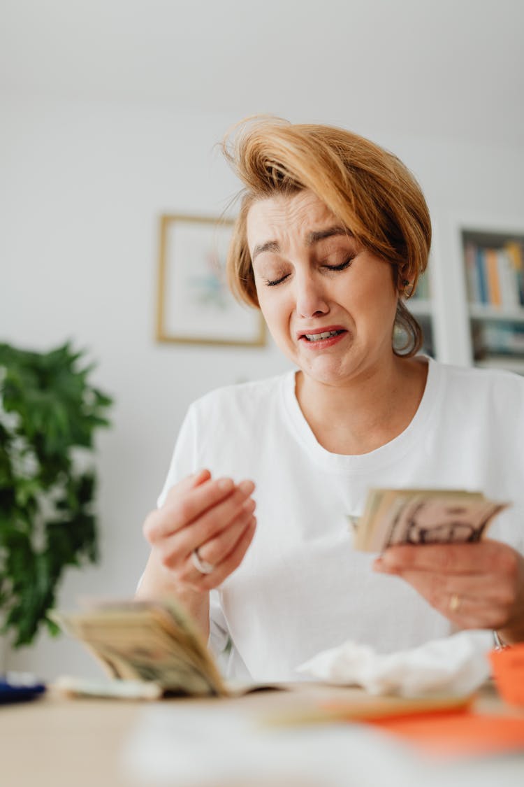 Woman Counting Money And Crying 