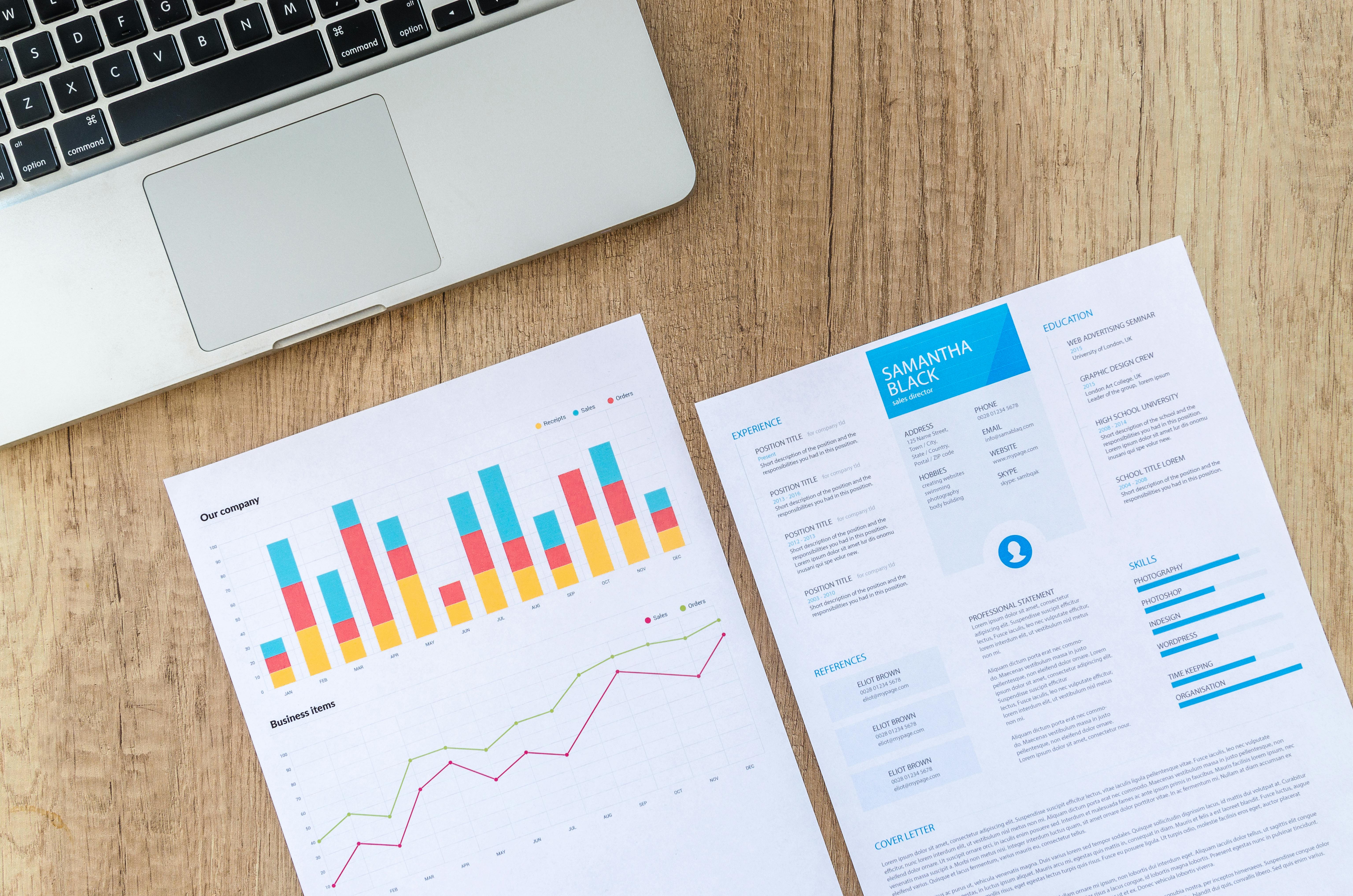 Two White Printer Papers Near Macbook on Brown Surface \u00b7 Free Stock Photo
