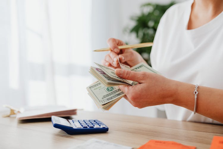 Woman Counting Money With Calculator