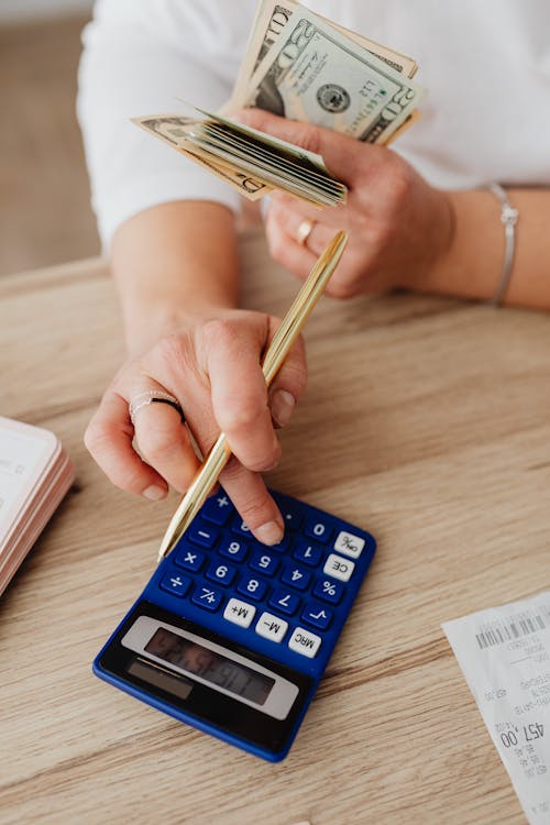Free Person Holding White Pen and Calculator Stock Photo
