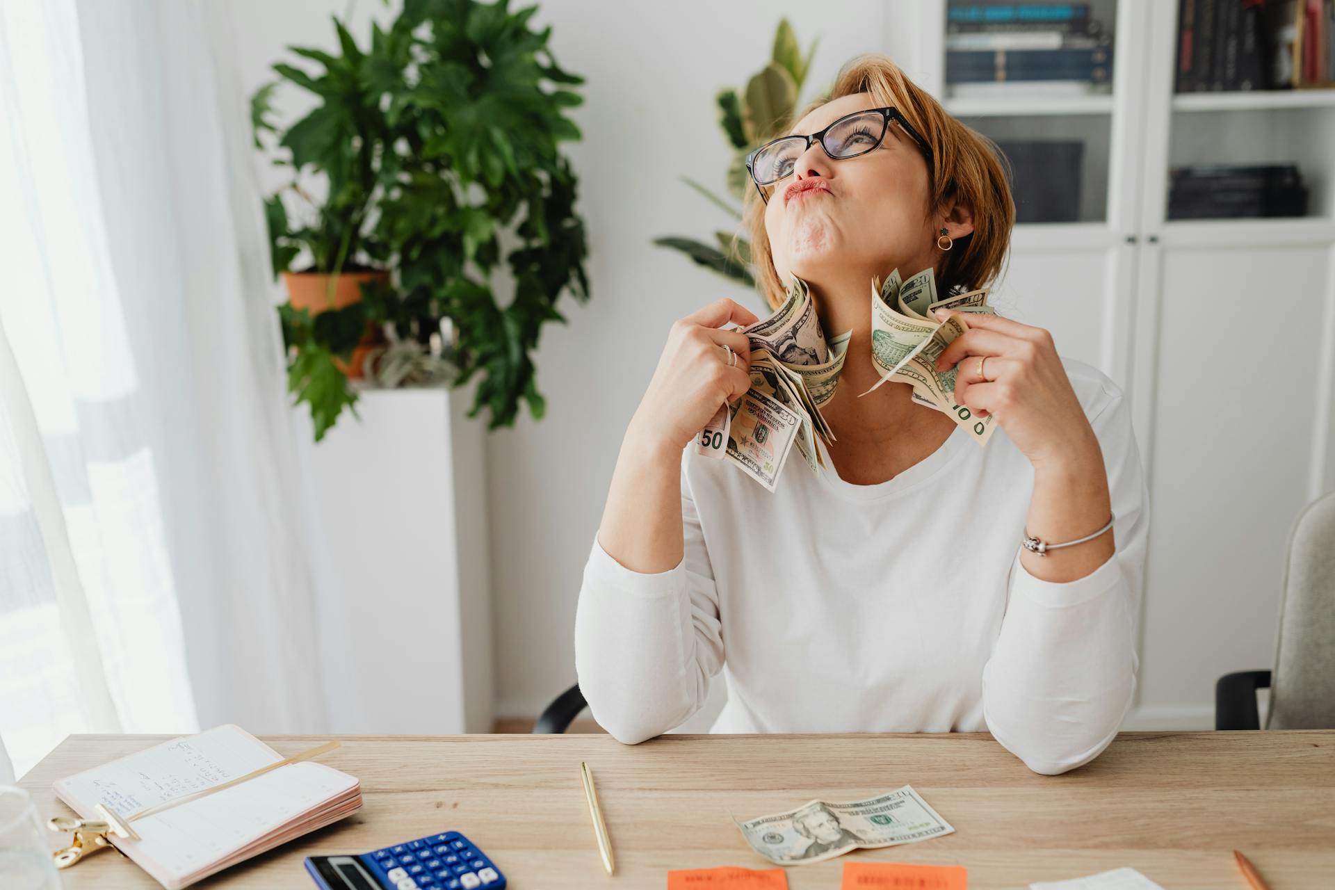 Woman in Eyeglasses Holding Dollar Bills