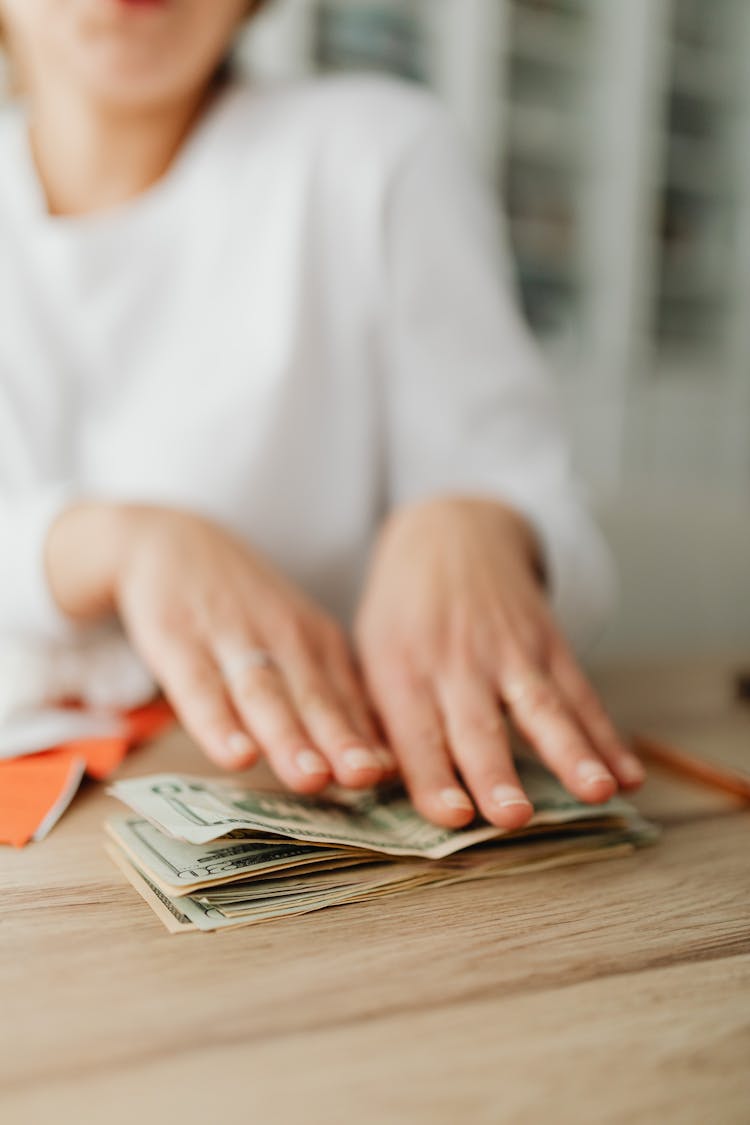 Woman Counting Money At Desk At Home