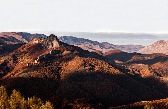 Breathtaking view of Apuseni Mountains in fall, showcasing vibrant foliage and rolling hills.