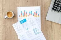 木制办公桌上摆放着文件、笔记本电脑和咖啡杯，营造出现代的办公氛围