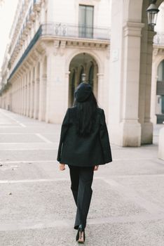 一位时尚女性的背影，走在欧洲历史悠久的街道上