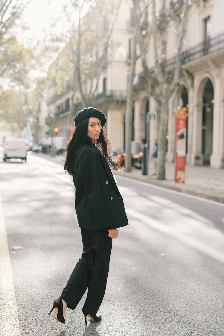 A Woman In Black Clothes Walking On The Street