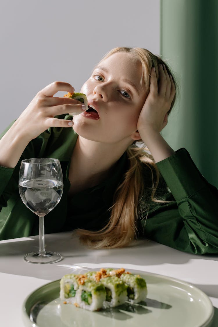 A Woman Eating A Sushi Roll