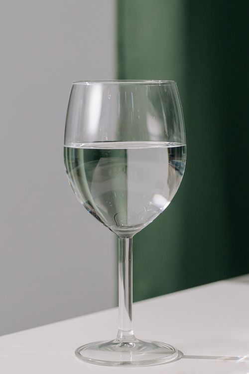 Free Close-up of a wine glass filled with water on a modern backdrop, ideal for minimalist themes. Stock Photo