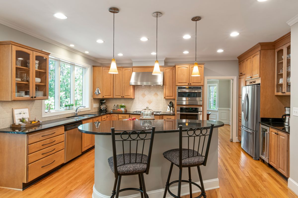 Bright elegant kitchen with wooden cabinetry and modern appliances