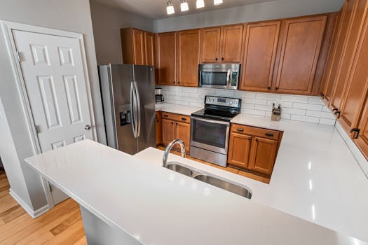 A contemporary kitchen featuring wooden cabinets, stainless steel appliances, and a sleek countertop.