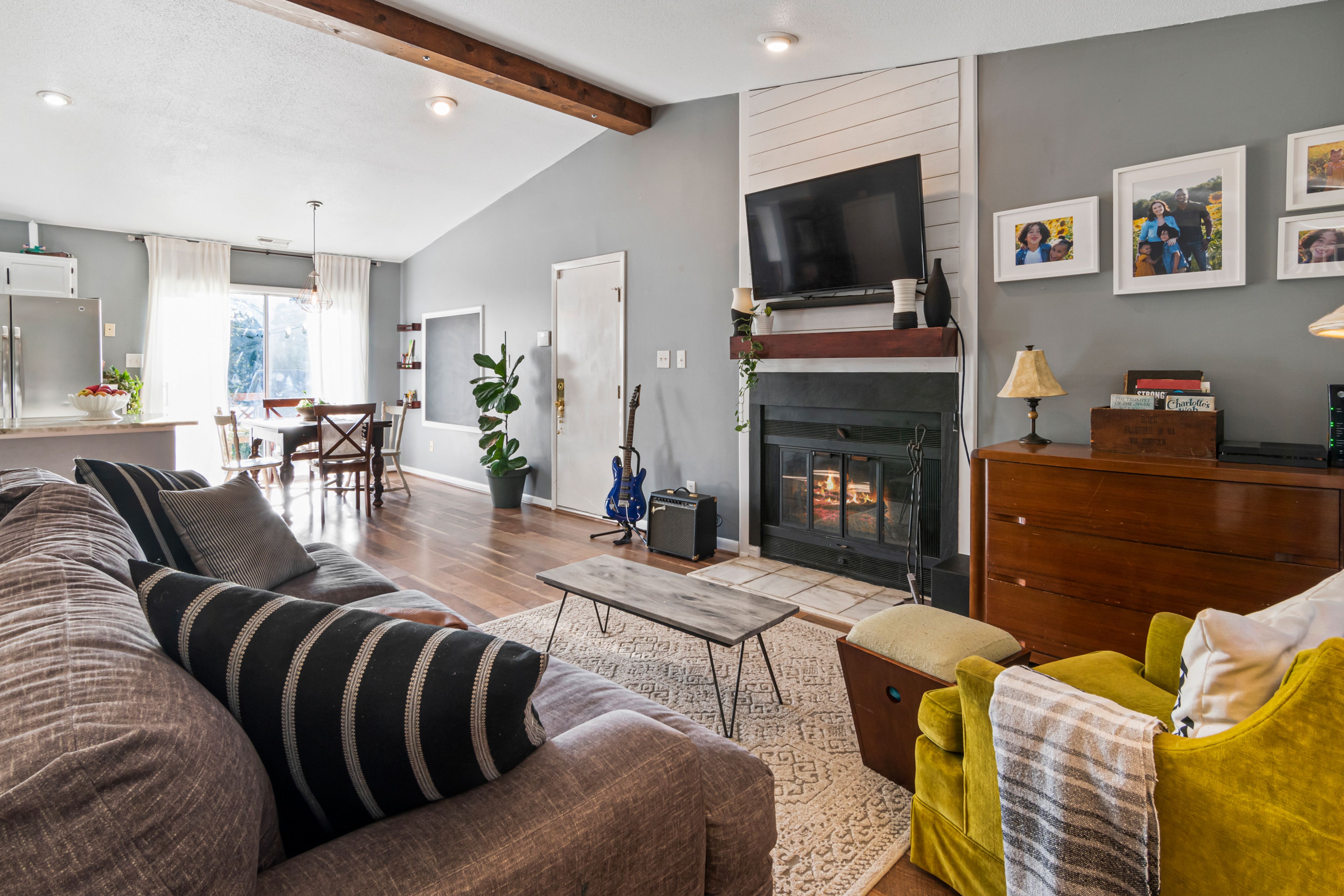 Cozy living room with a fireplace, low coffee table and comfortable seating, filled with soft natural light