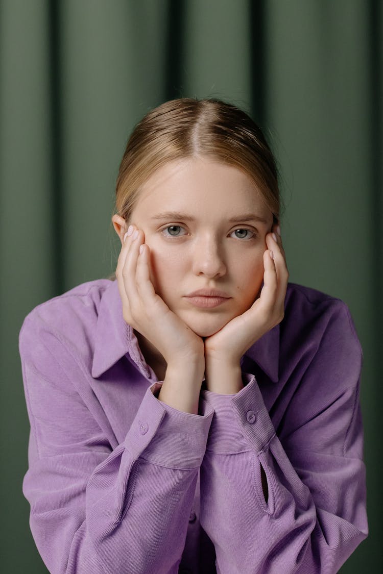 A Woman In Purple Long Sleeves Looking With A Serious Face