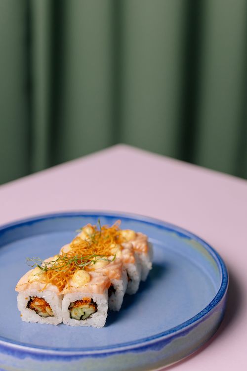 Free Close-up of a delicious sushi roll on a blue plate, showcasing culinary art. Stock Photo