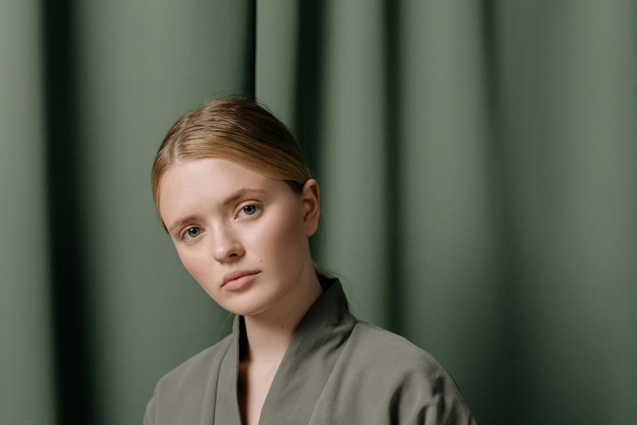 A woman in a grey linen top looking calmly at the camera
