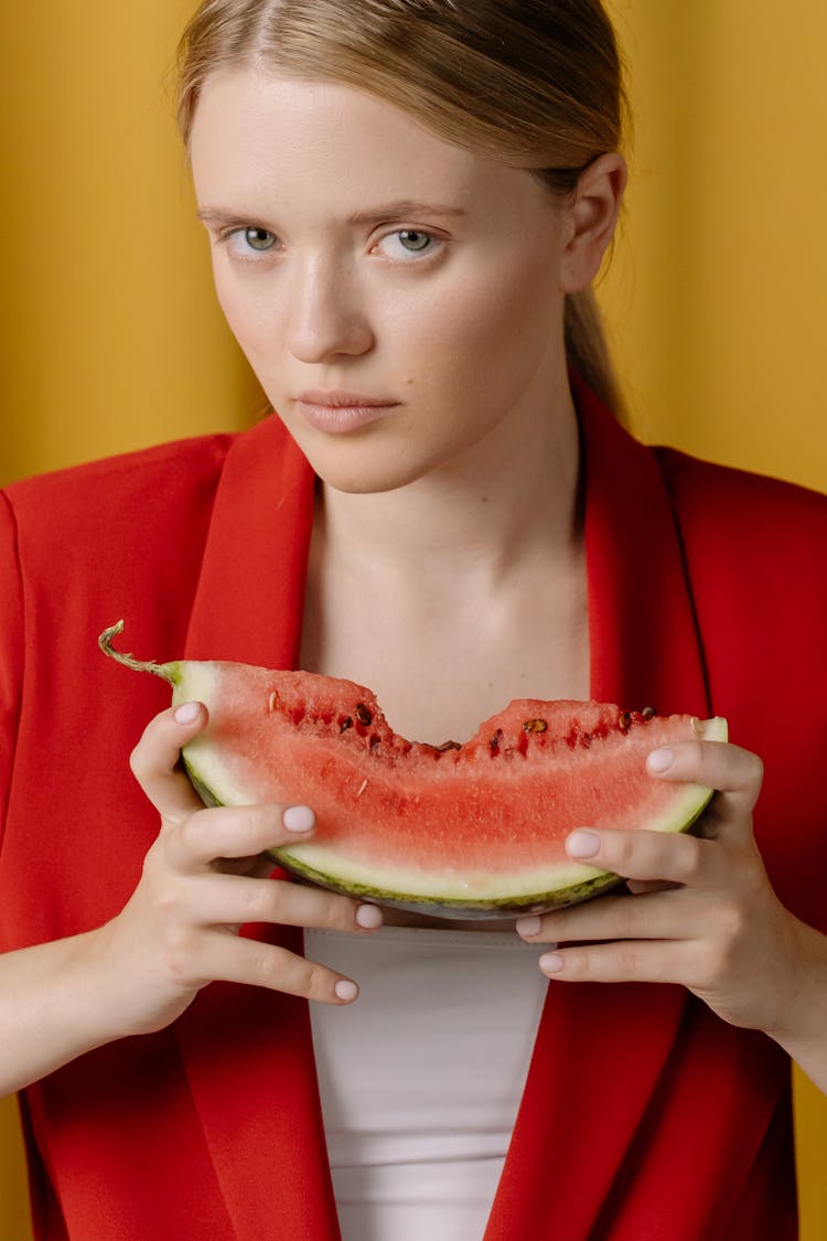 A Woman In Red Blazer Holding A Watermelon