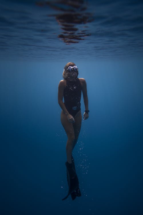 Active female diver swimming with mask and flippers in sea