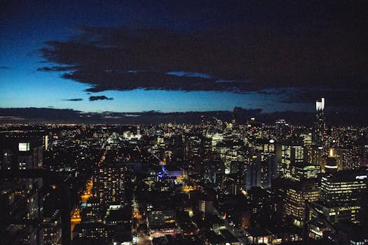 A breathtaking aerial view of a city skyline illuminated against the night sky, showcasing urban architecture.