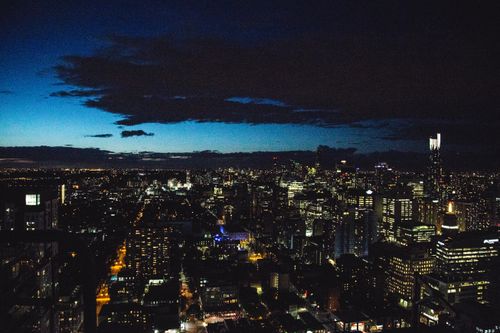 Free A breathtaking aerial view of a city skyline illuminated against the night sky, showcasing urban architecture. Stock Photo