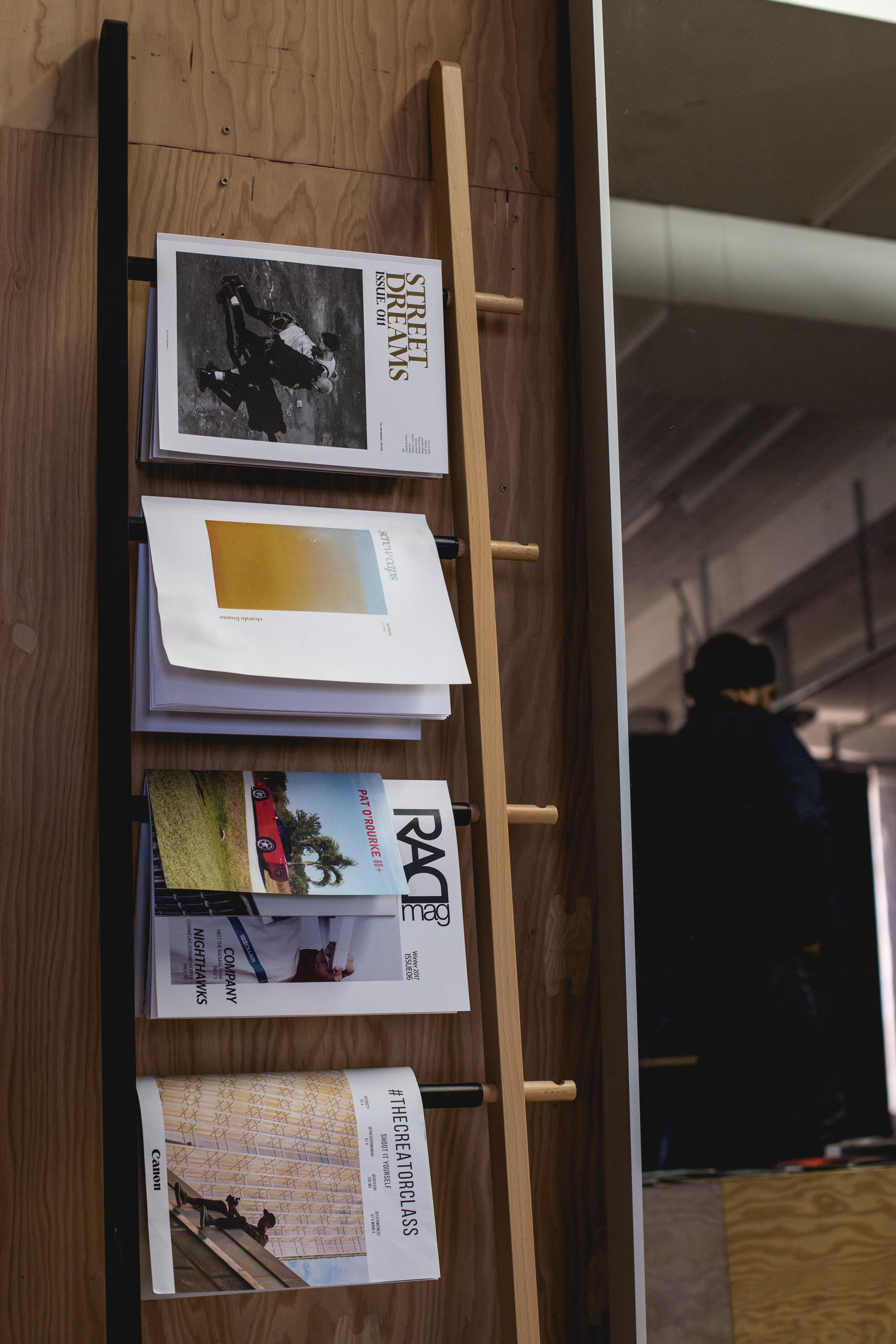 Sleek modern office interior featuring a stylish wooden magazine rack against a wooden wall.