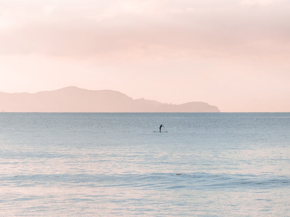 Homem A Remar Um Barco No Mar Durante O Dia