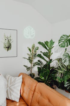 Modern living room with orange sofa, green plants, and wall art. Perfect for interior design inspiration.