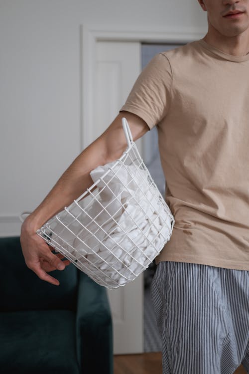 Free Man Holding Basket with Bed Sheets Stock Photo