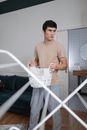 Man in Brown Crew Neck T-shirt Standing Beside White Metal Frame