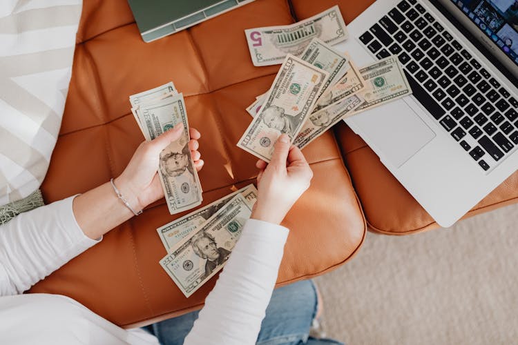 Close-up Of Woman Counting Dollar Bills