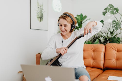 Woman with Headphones Giving Online Guitar Classes