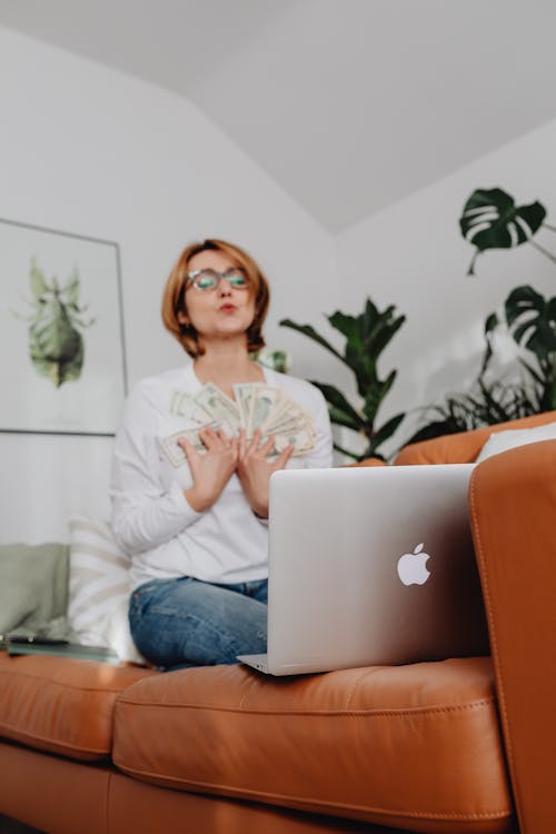 Woman on Sofa with Cash in Hand