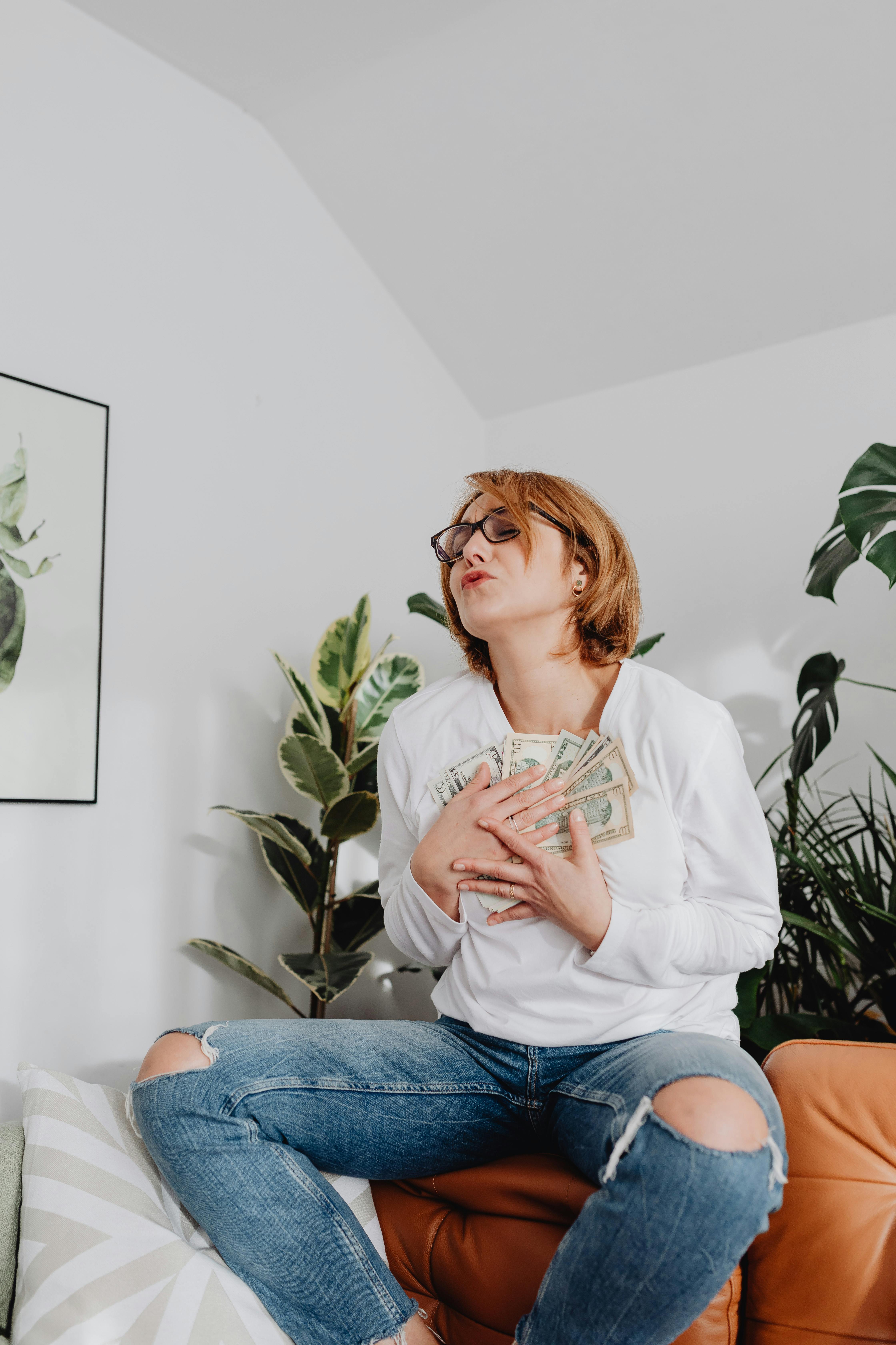 woman holding banknotes to her chest