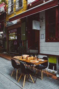优雅的户外用餐场景，配上比萨饼和木桌，构成完美舒适的一餐