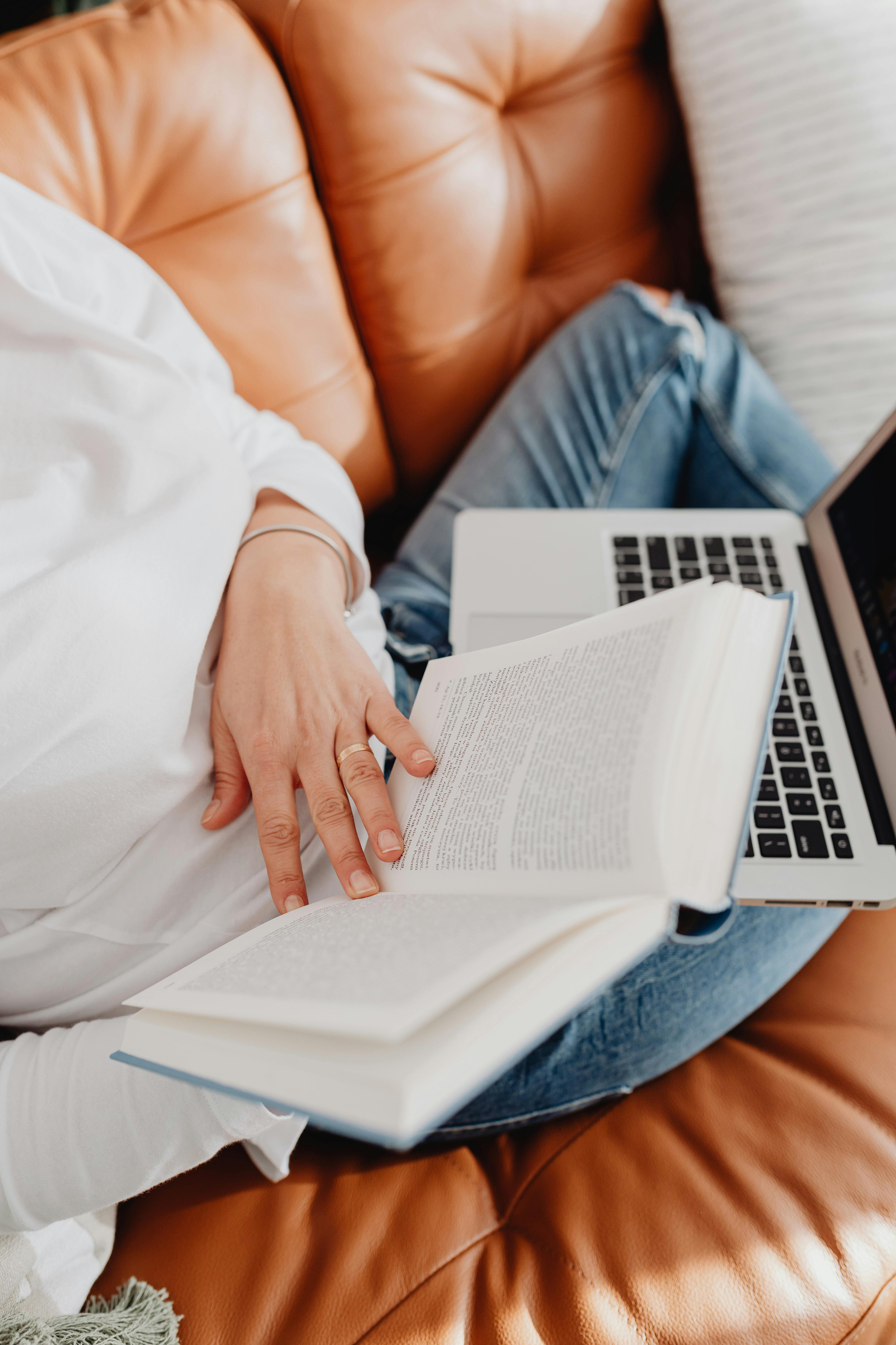 A Person Reading a Book while Sitting on a Couch