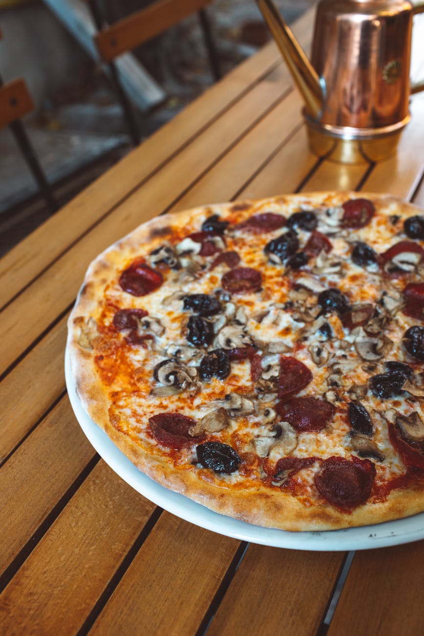 Delicious pepperoni and mushroom pizza on a wooden table.