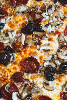 A mouthwatering close-up shot of pepperoni and mushroom pizza with melted cheese.