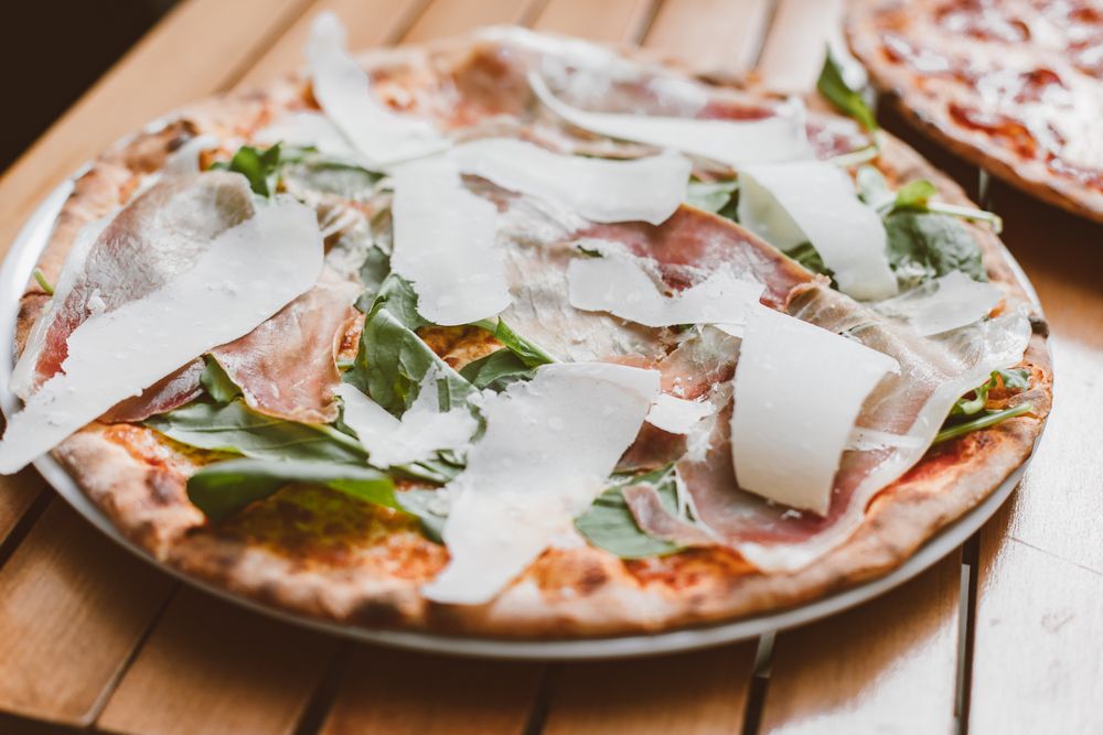 Pizza italiană cu prosciutto, rucola și parmezan