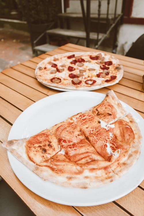 A Plate of Crepe and Pizza on a Wooden Table