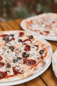 Mouthwatering pepperoni and mushroom pizza on a wooden table, perfect for food lovers.
