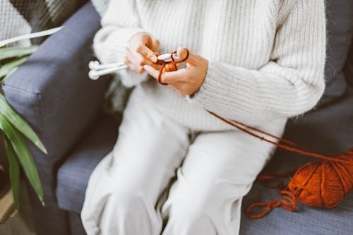 Person in White Sweater Knitting