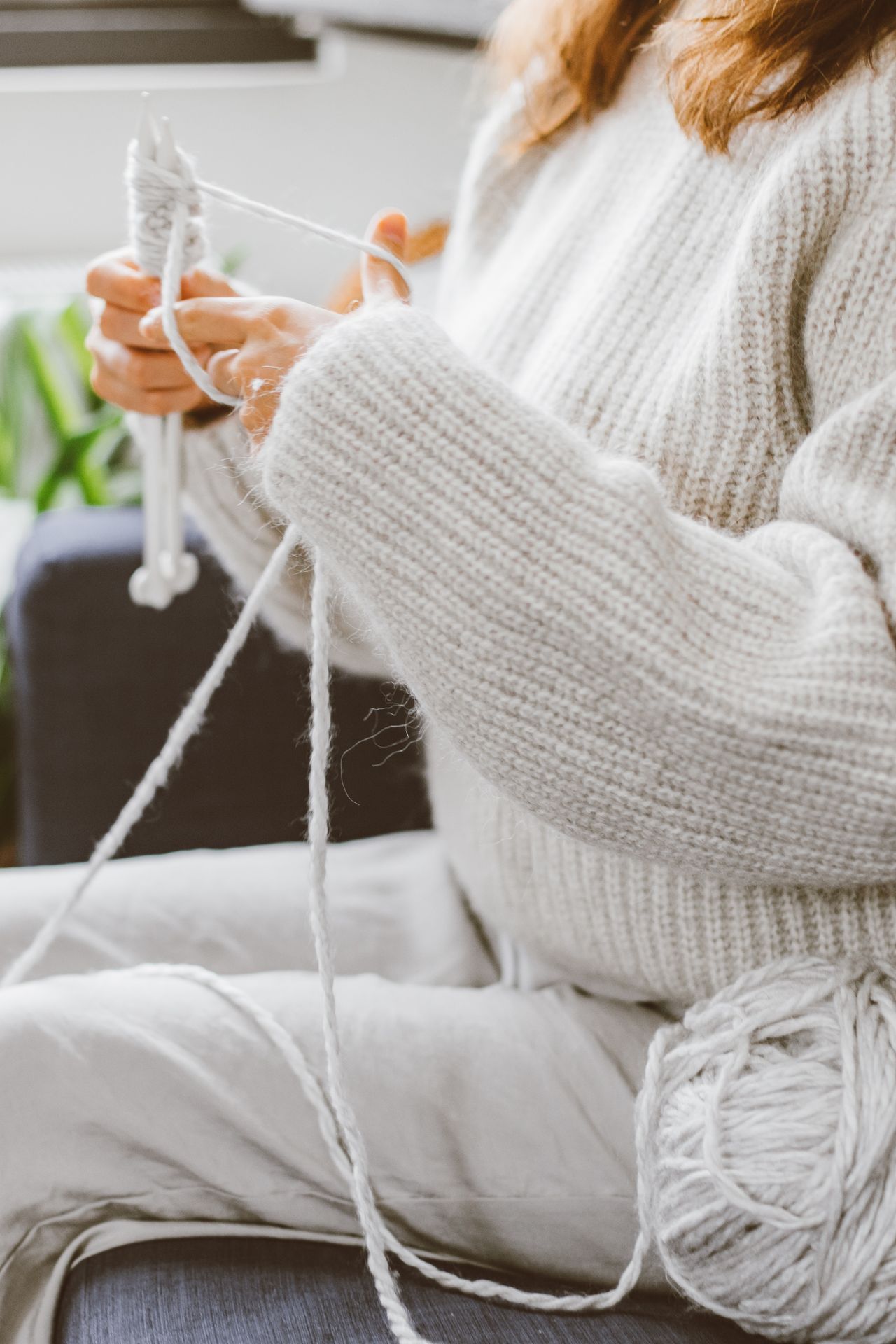 Hands knitting with soft white yarn