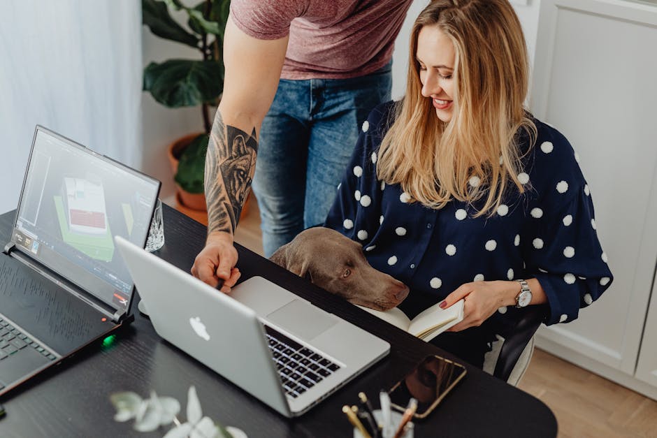 What FDA Research Reveals About Grain-Free Dog Food and DCM Risk A woman multitasking at home with a laptop, book, and her dog for company.