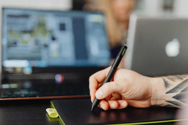 Close Up Shot Of A Person Holding A Black Stylus