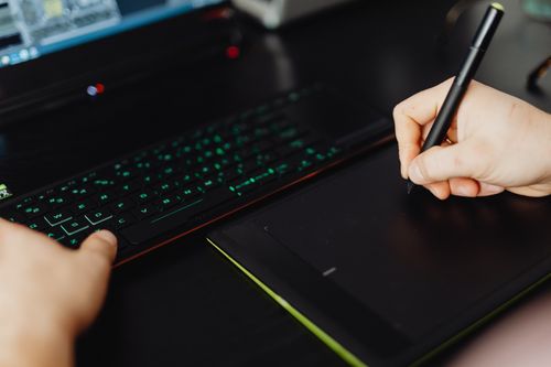 Hand writing with a stylus on a drawing tablet — photo by Kaboompics on Pexels