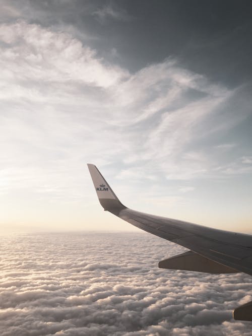 Free Airplane wing above clouds under sky Stock Photo