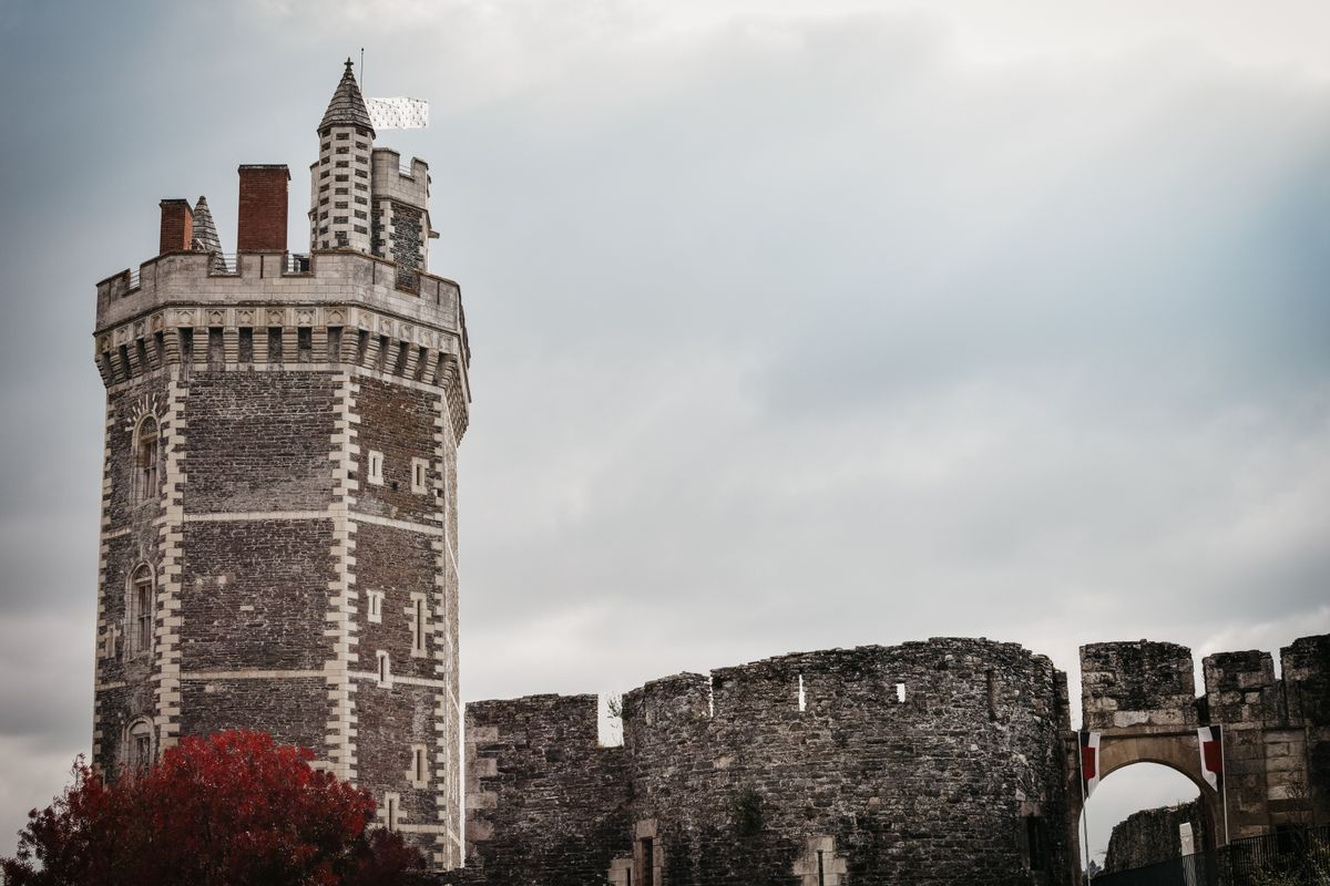 Castel medieval cu turnuri, sub cer înnorat