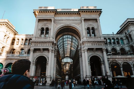 Iconic Galleria Vittorio Emanuele II facade in Milan bustling with people and architectural grandeur.