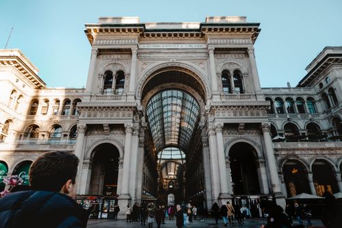 Free Iconic Galleria Vittorio Emanuele II facade in Milan bustling with people and architectural grandeur. Stock Photo