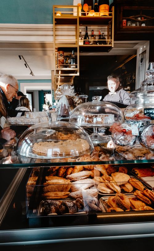 Free Cozy café in Livorno, Italy, offering a delectable variety of pastries and baked goods. Stock Photo