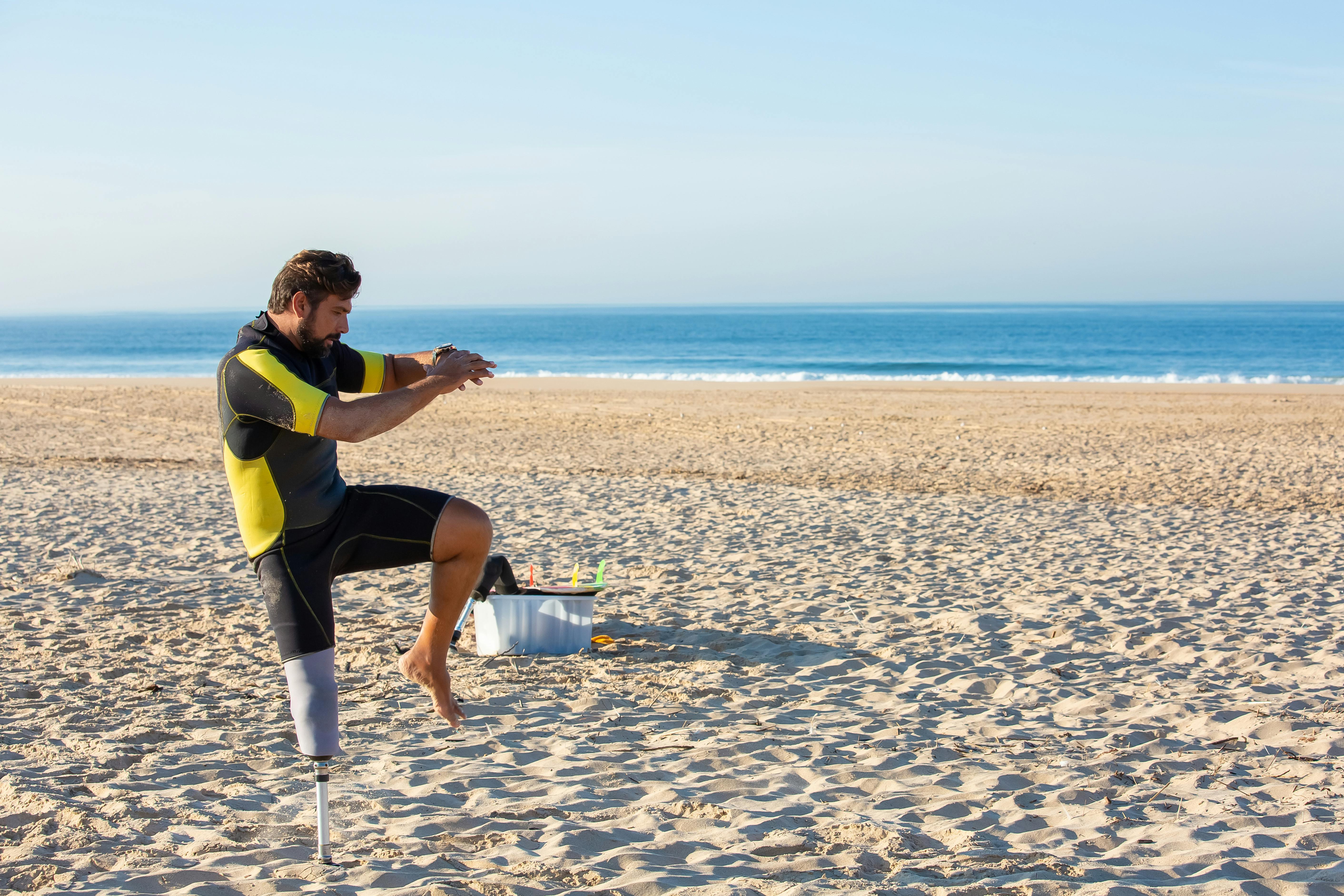 Faceless muscular man jogging on wet scenic seashore · Free Stock Photo